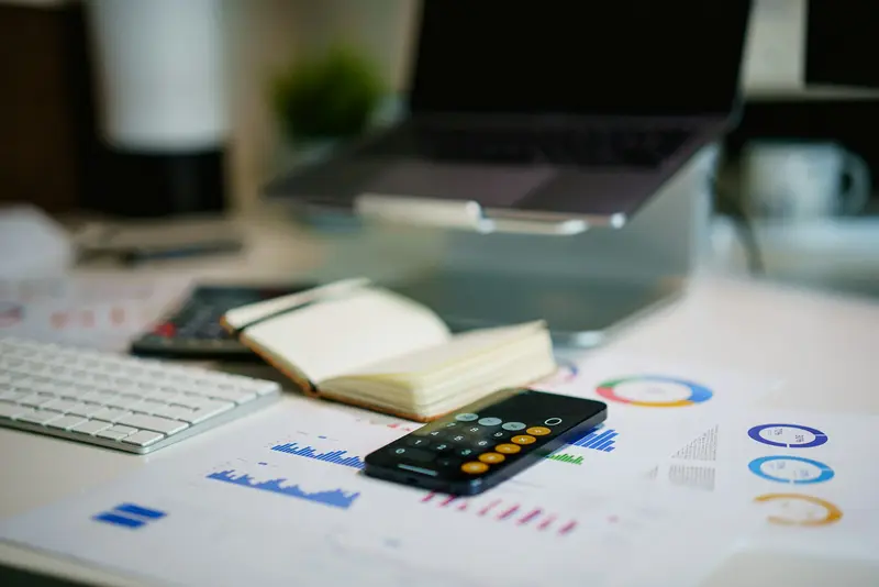 a desk with financial charts and a calculator