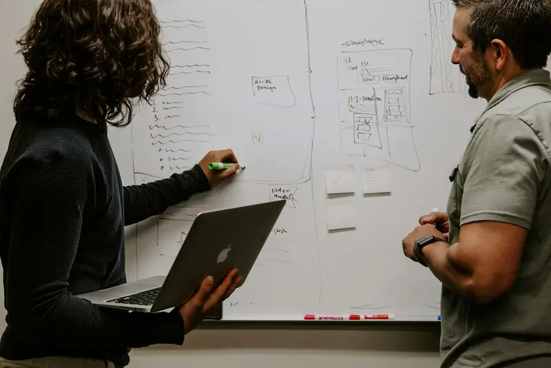 two people planning at a whiteboard