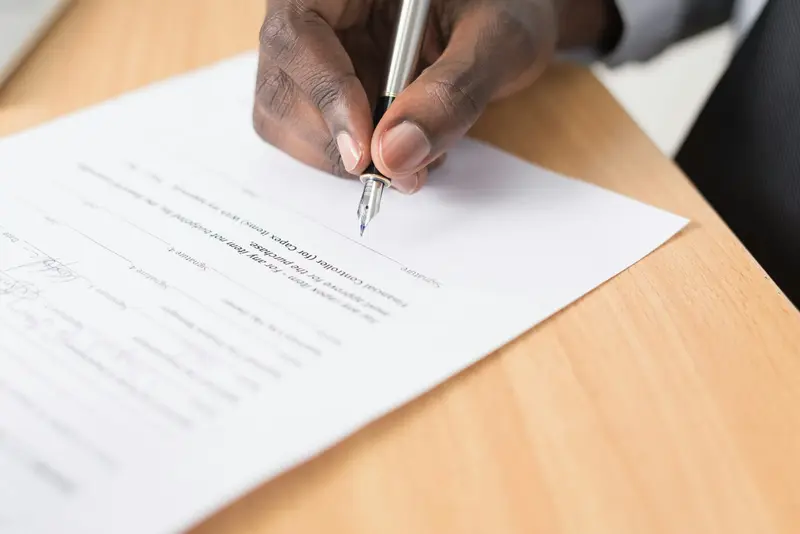 a hand filling in a document